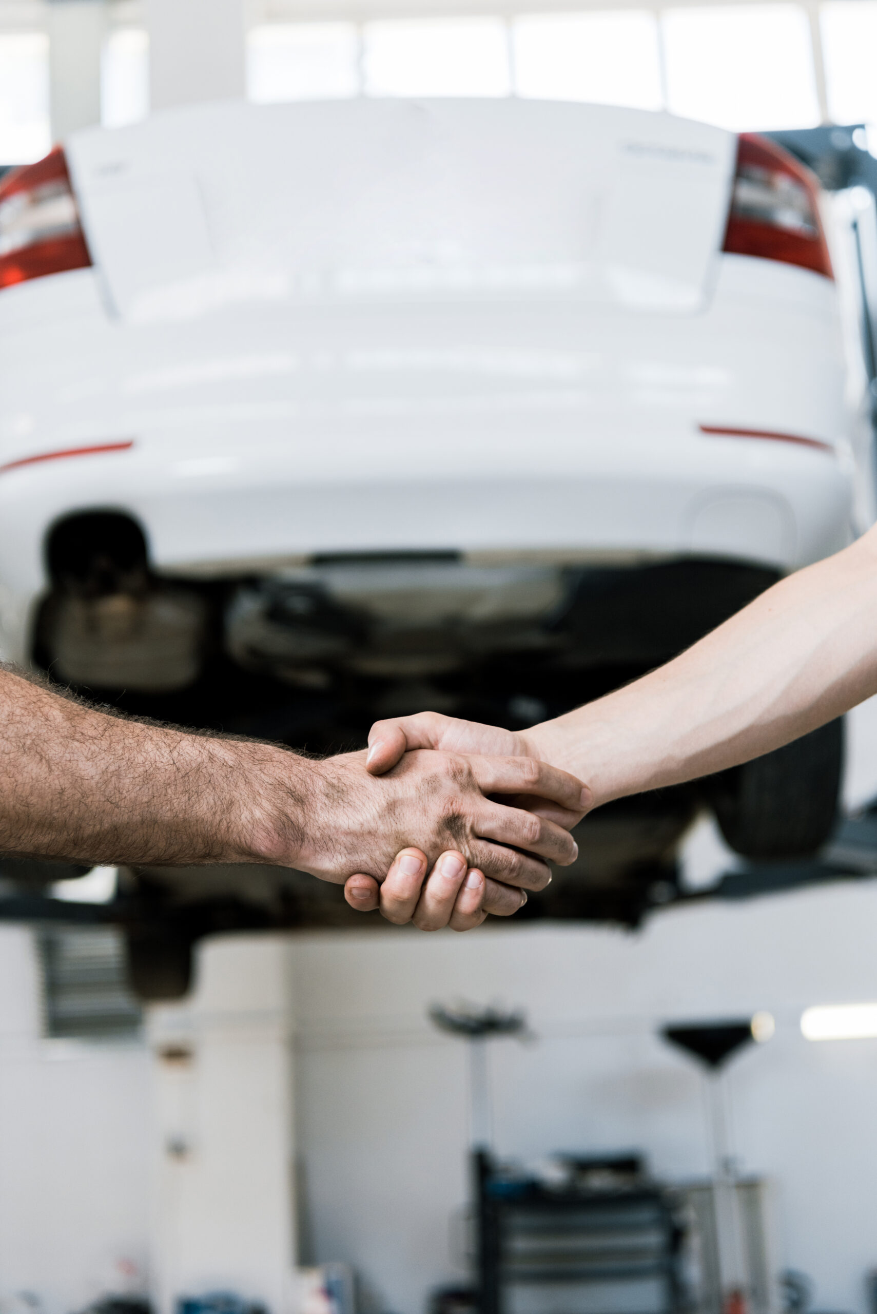 Auto mechanic checking oil in car engine while working in auto repair workshop
